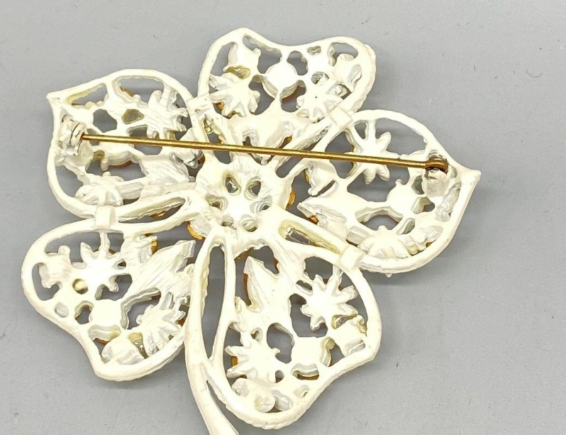 Vintage White Enamel Flower Brooch with Pastel Rhinestones – UV Reactive Green Stones  Description