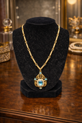 Gold tone filigree pendant necklace with blue crystal and faux pearl frame