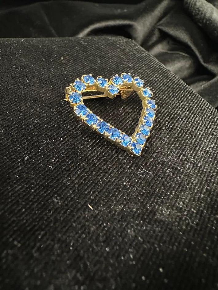 Gold tone open-heart brooch with blue rhinestones