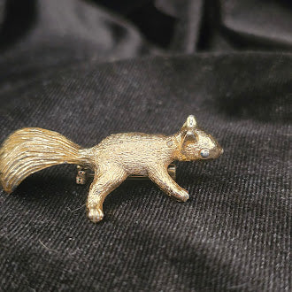 Gold tone squirrel brooch with textured finish and blue eye detail