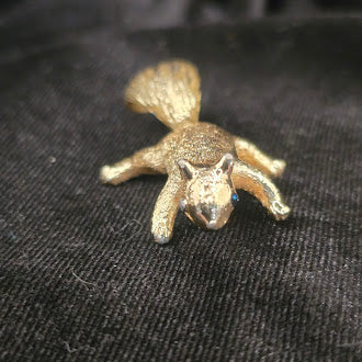 Gold tone squirrel brooch with textured finish and blue eye detail
