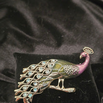 Gold tone enamel peacock brooch with green and purple body and blue stones