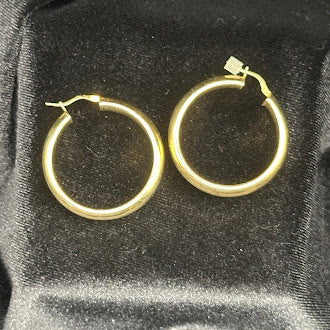 Gold tone hoop earrings with rounded tubular profile