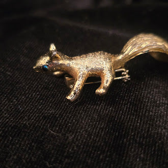 Gold tone squirrel brooch with textured finish and blue eye detail