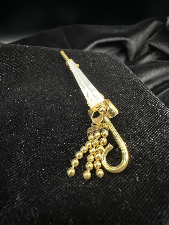 Gold tone umbrella brooch with white carved look panel and bead tassel detail